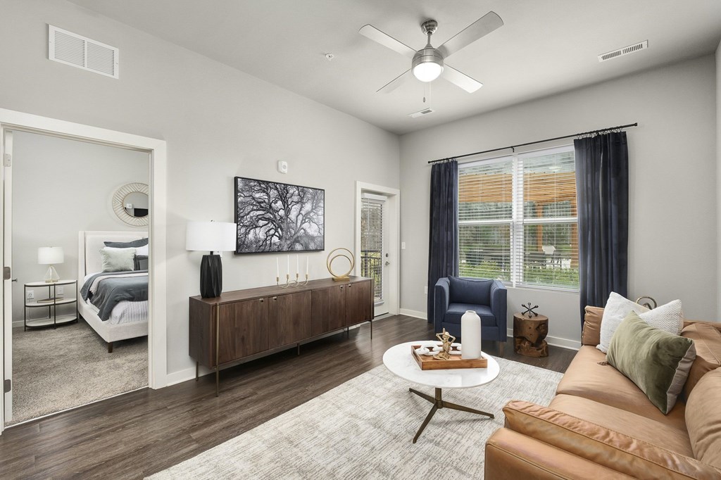 A modern living room with a brown sofa and a wooden coffee table at The Percy Apartments, Tennessee, 37214