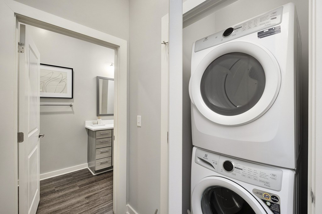 A white washer and dryer stacked on top of each other in a laundry room at The Percy Apartments, Nashville, Tennessee