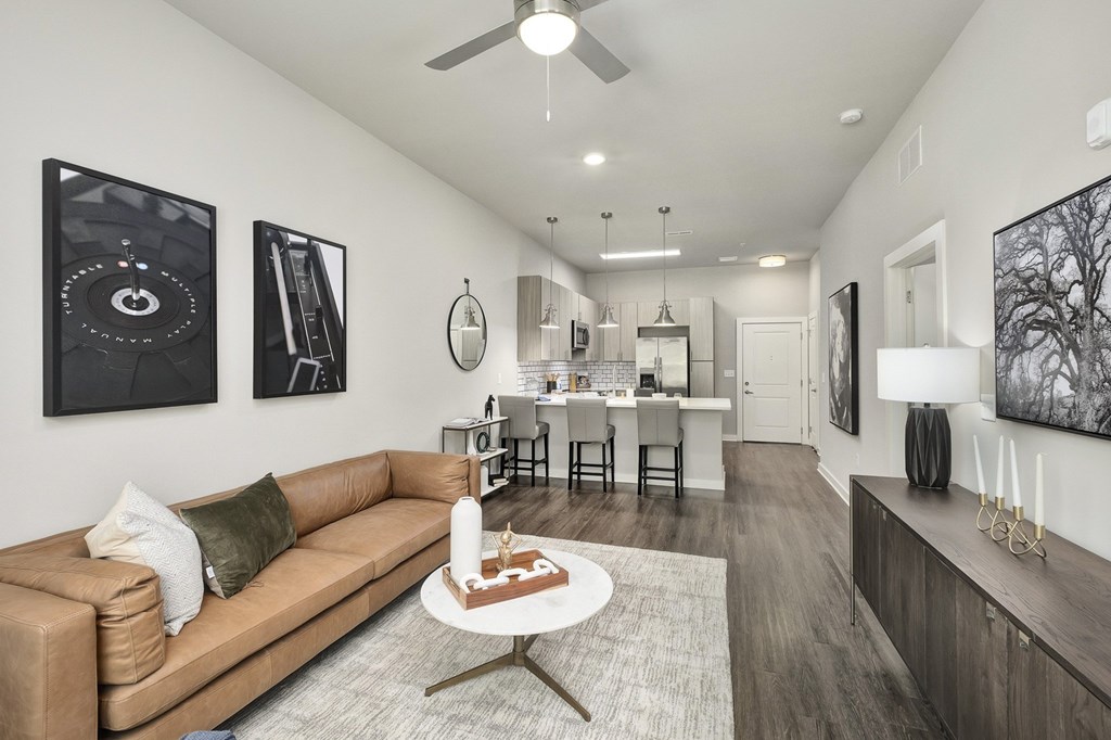 A living room with a tan couch and a coffee table in the middle at The Percy Apartments, Nashville