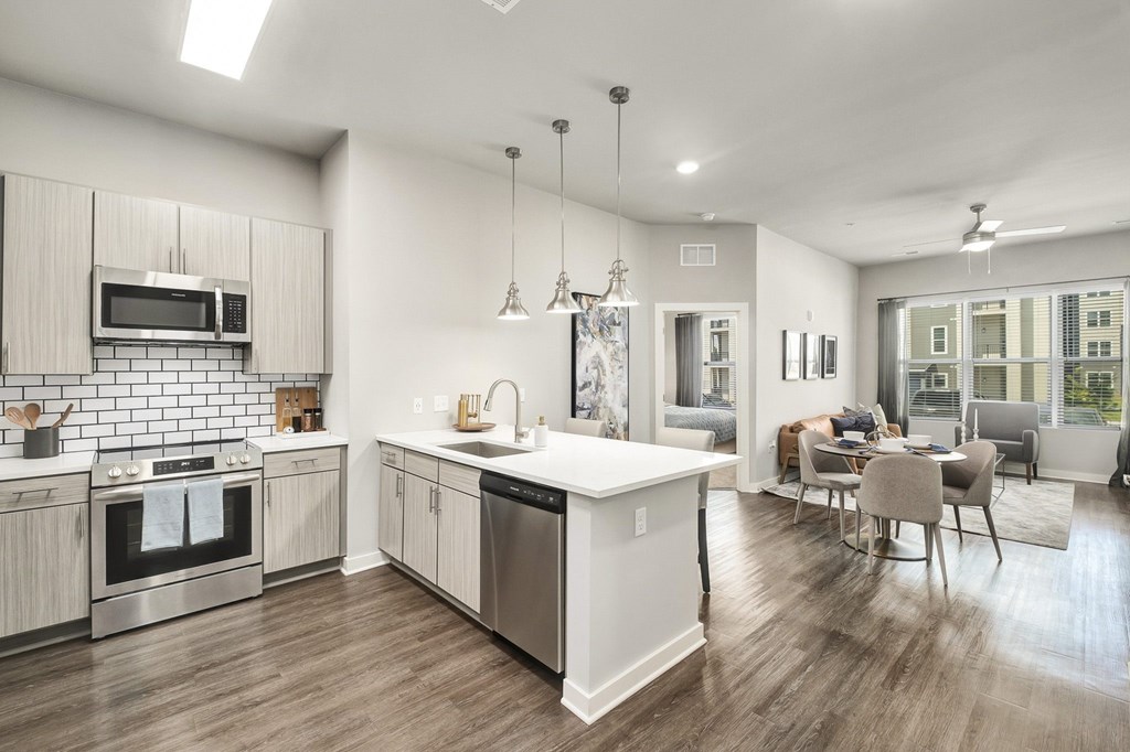 A modern kitchen with wooden floors and stainless steel appliances at The Percy Apartments, Nashville, TN