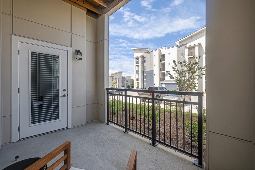 A balcony with a black railing and a white door at The Percy Apartments, Nashville, 37214