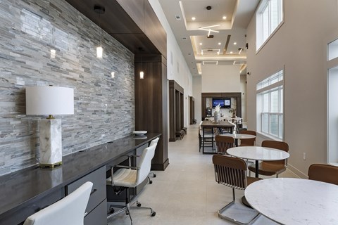A modern dining area with a stone wall and a television.