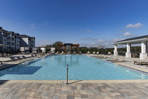 A large swimming pool with a depth marker in the middle at The Waverly at Winter Haven Apartments, Winter Haven