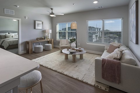 A well-lit, modern living room with a large couch and a coffee table at The Waverly at Winter Haven Apartments, Winter Haven, Florida