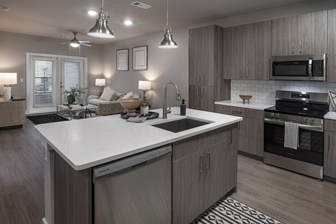 A modern kitchen with a large island and stainless steel appliances at The Waverly at Winter Haven Apartments, Winter Haven, FL, 33884