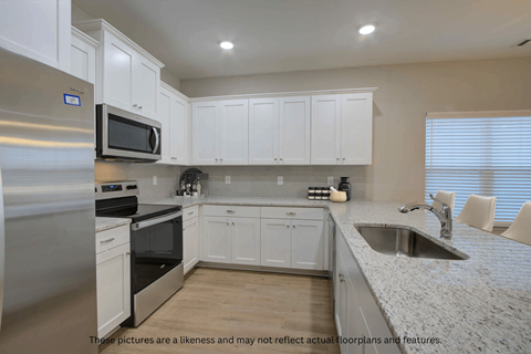 A kitchen with white cabinets and stainless steel appliances.