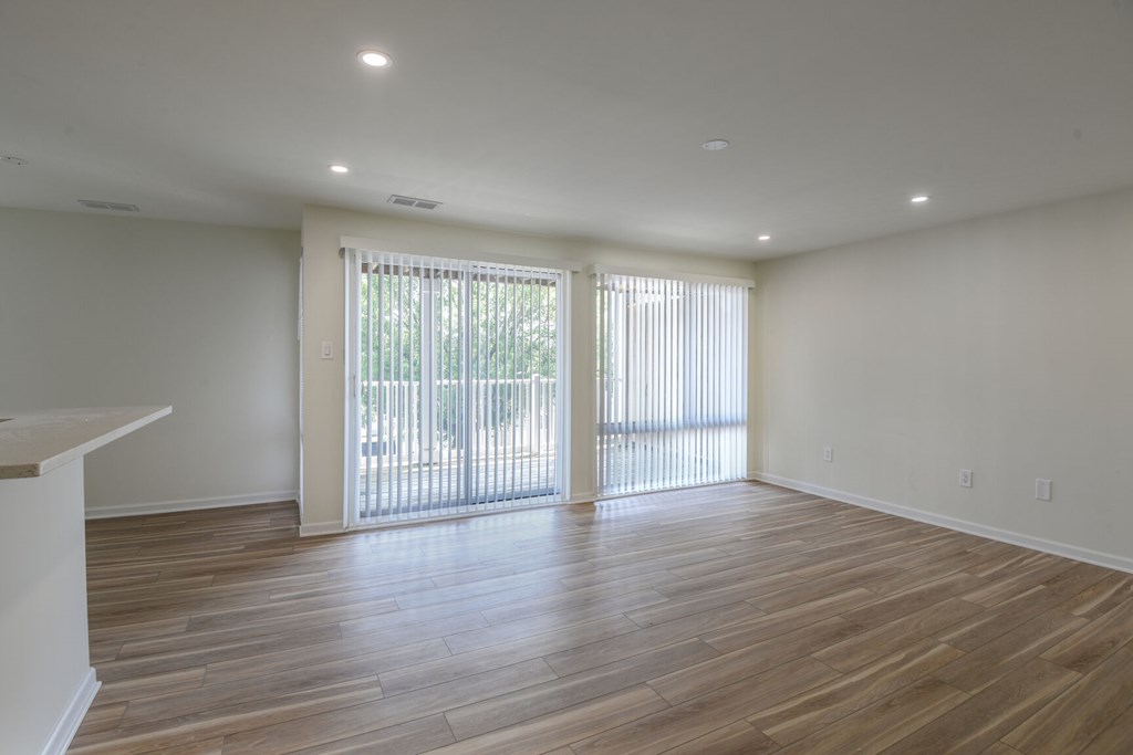 A room with wooden floors and sliding glass doors.