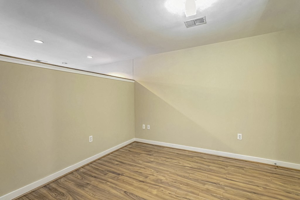 a empty room with wood flooring and white walls