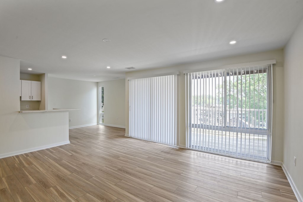 A large empty room with wooden floors and white walls.