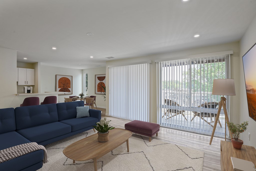A blue sofa sits in a living room with a wooden coffee table in front of it.