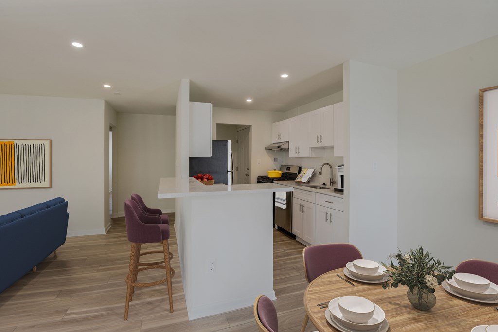 A modern kitchen with a dining table set for two.