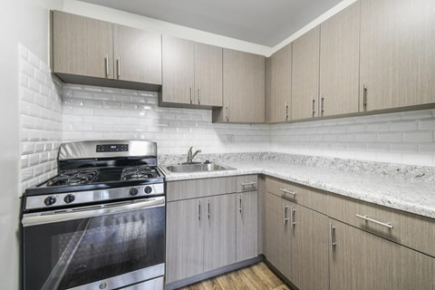 A modern kitchen with a stove and cabinets.