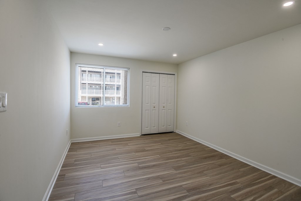 A room with a wooden floor and a window.