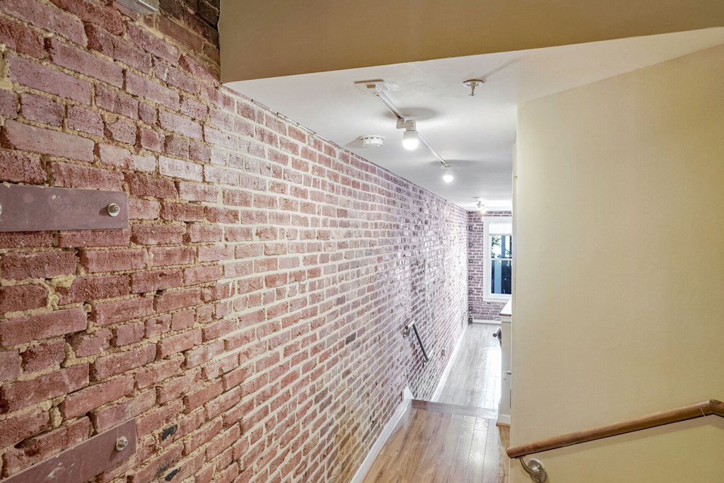 an exposed brick wall in a hallway of a house