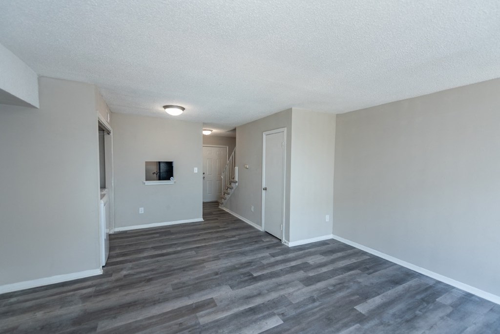 the spacious living room and hallway of an apartment
