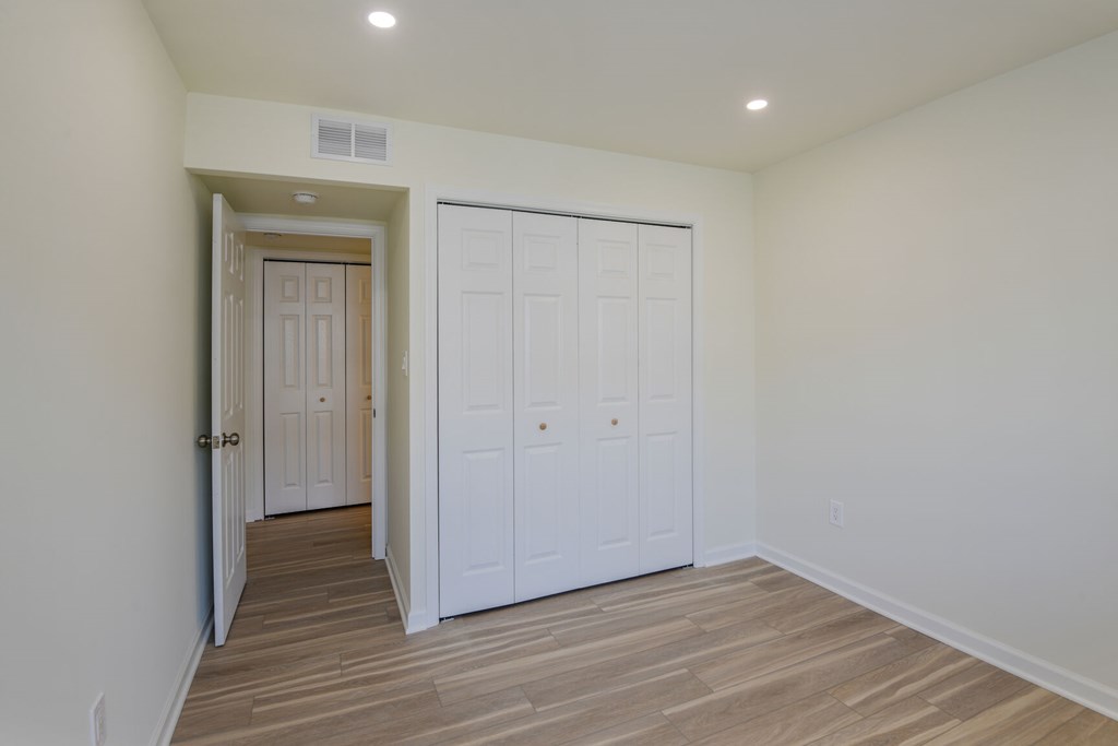 A room with a white door and a white closet.