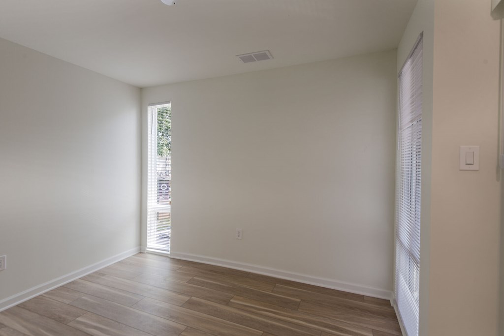 A room with wooden flooring and a window.