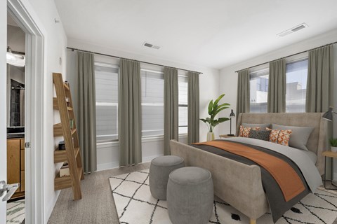 A bedroom with a large bed and a wooden ladder.
