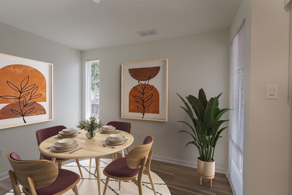 A dining room with a round table and chairs.