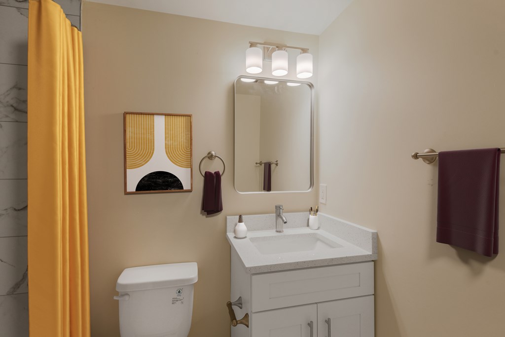 A bathroom with a toilet, sink, mirror, and a yellow curtain.
