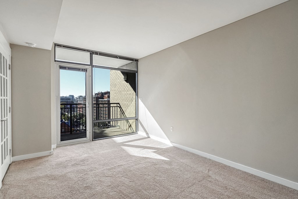 a living room with a balcony and sliding glass doors
