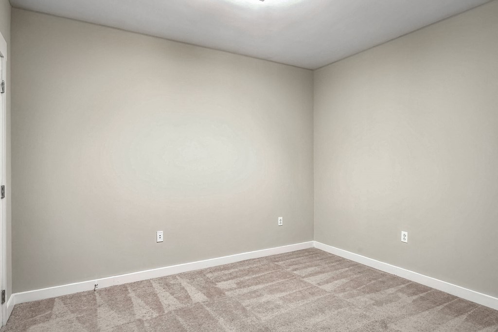 a empty room with a carpeted floor and white walls