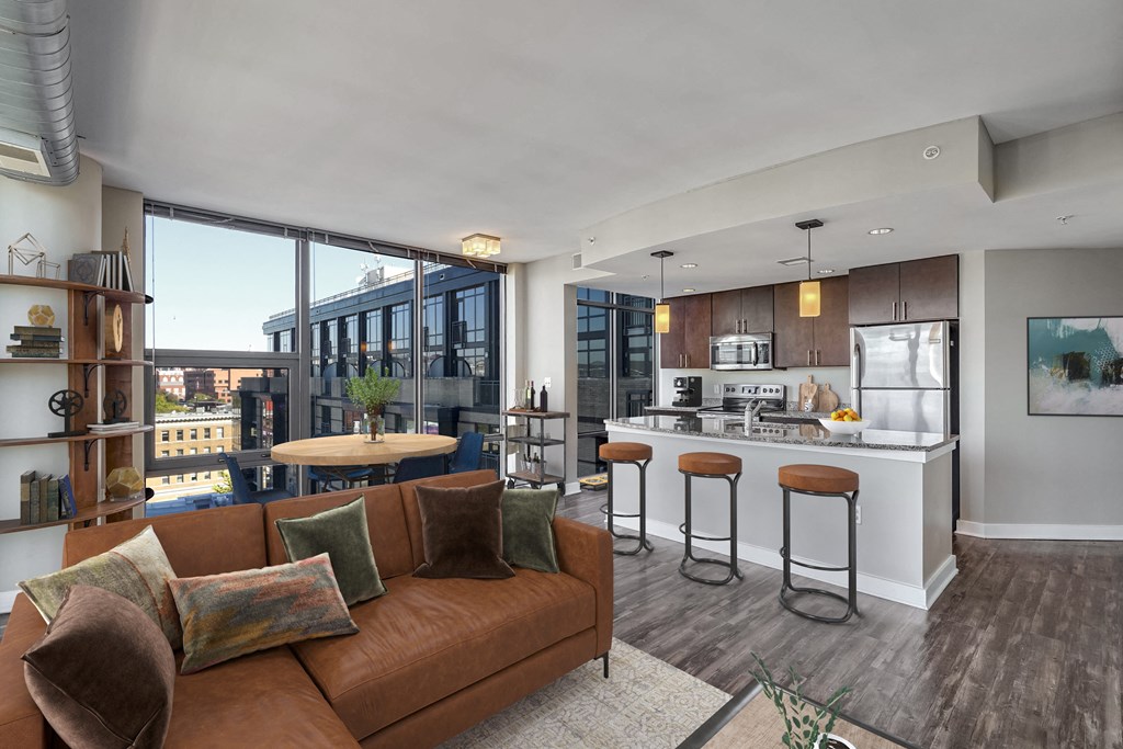 a living room with a couch and a kitchen with a bar