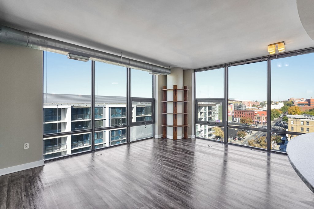 an open living room with windows and a view of a city