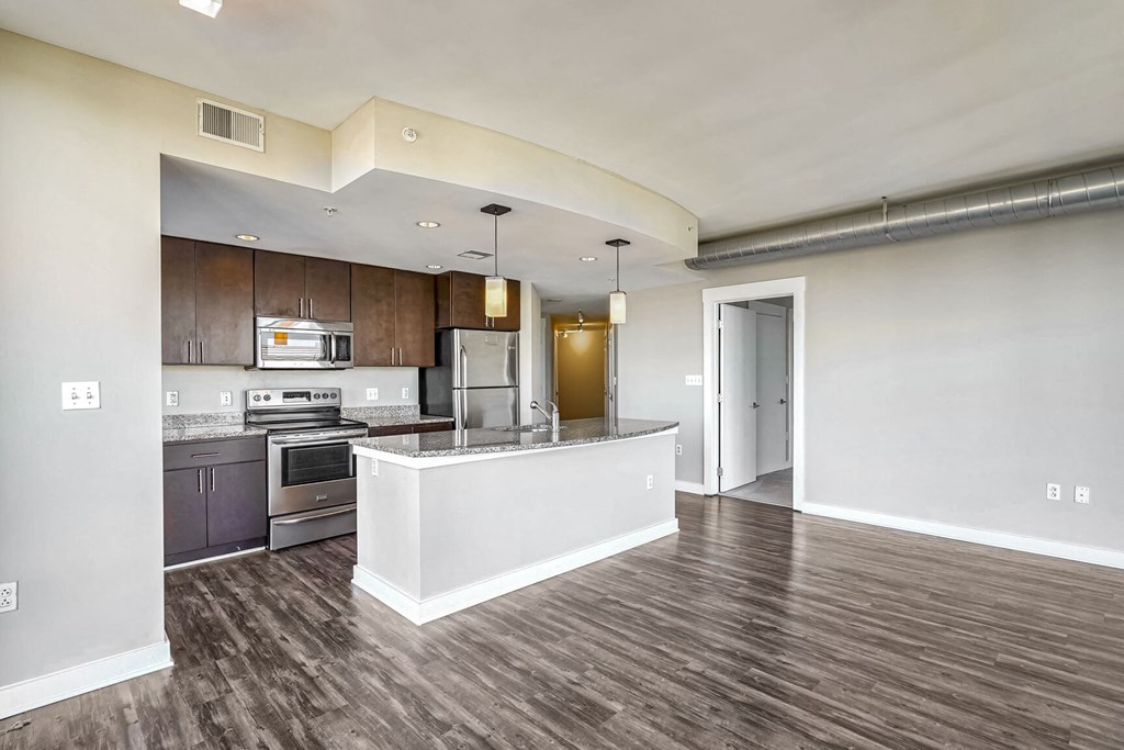 an open kitchen and living room with wood flooring