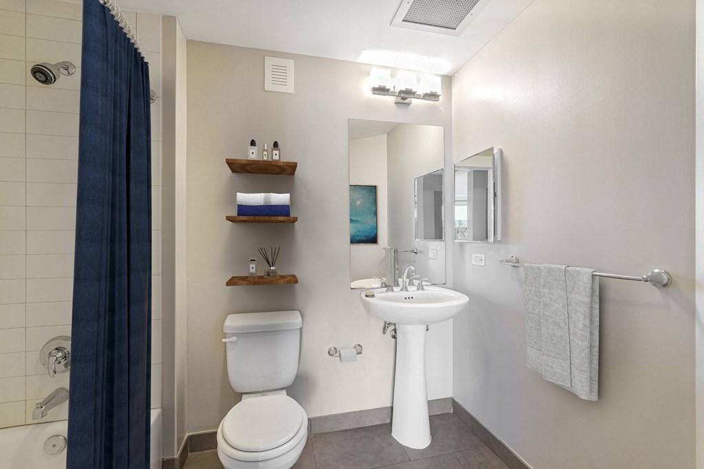 a bathroom with a toilet sink and mirror and a shower