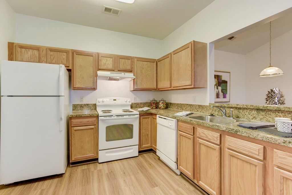a kitchen with white appliances and wooden cabinets