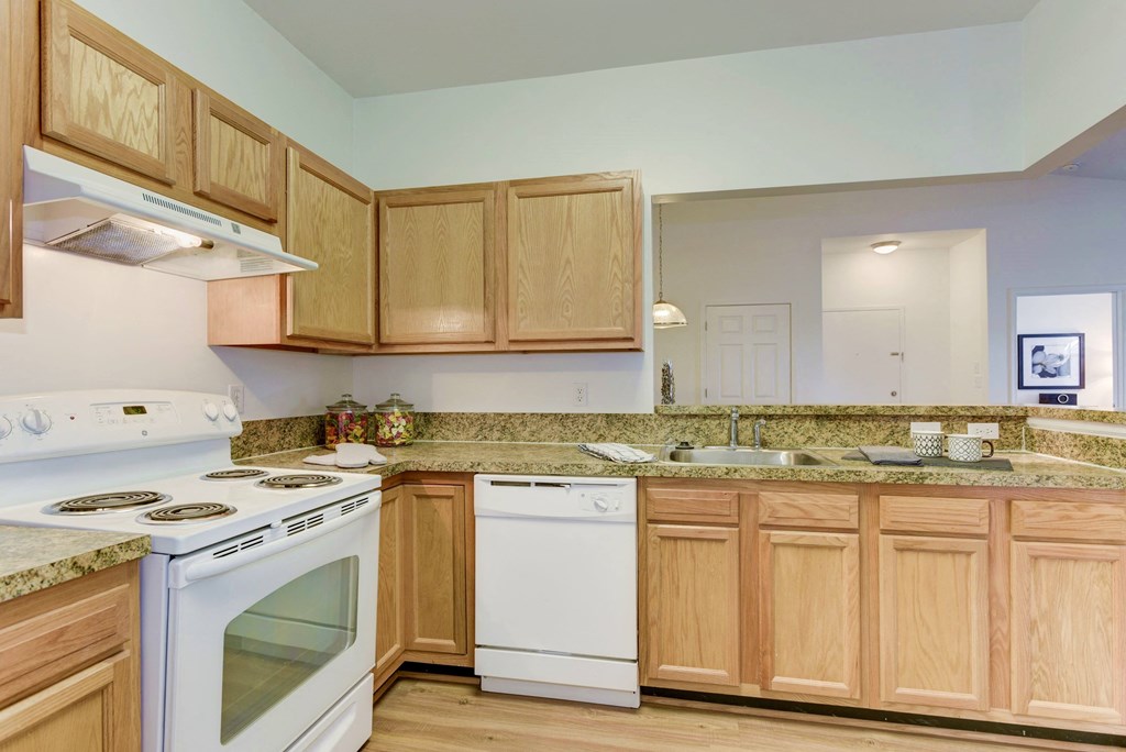 a kitchen with white appliances and wooden cabinets