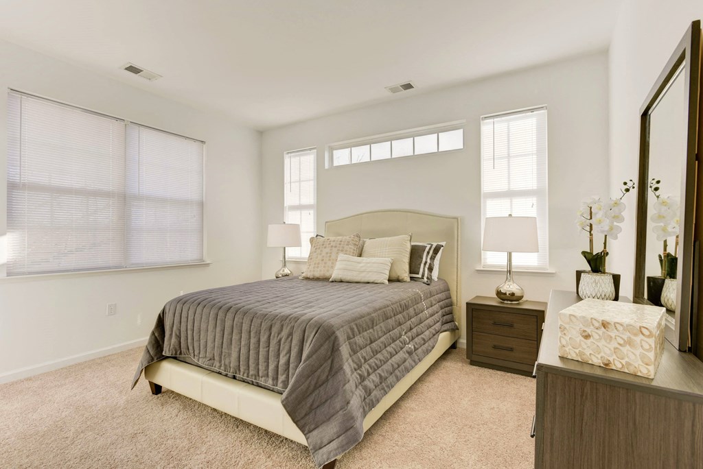 a bedroom with a bed and two windows