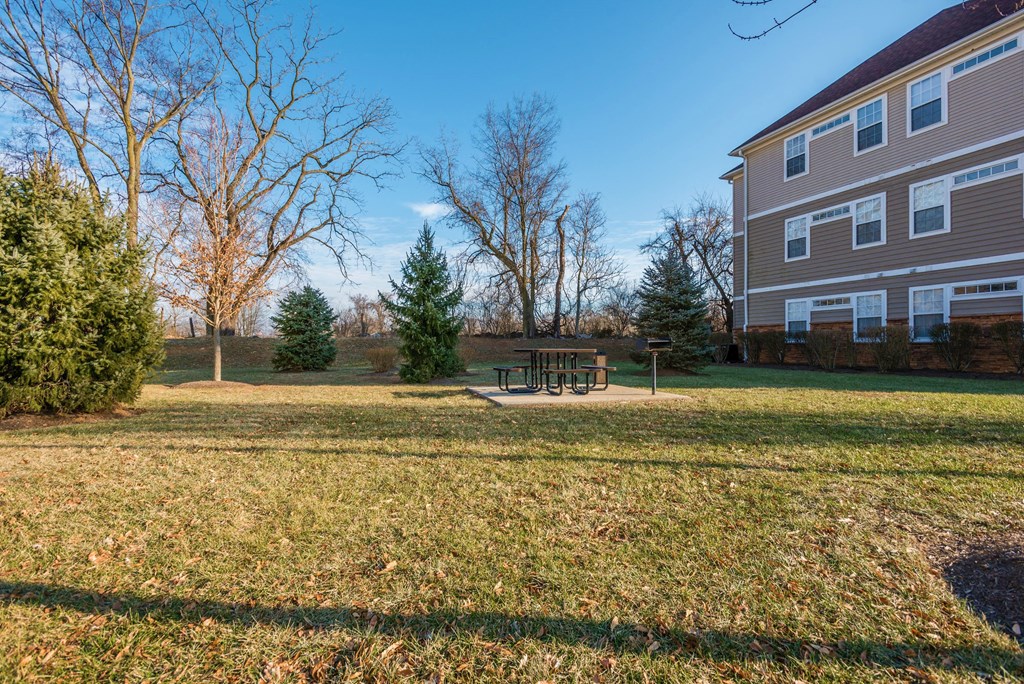 a yard with a picnic table in front of a house