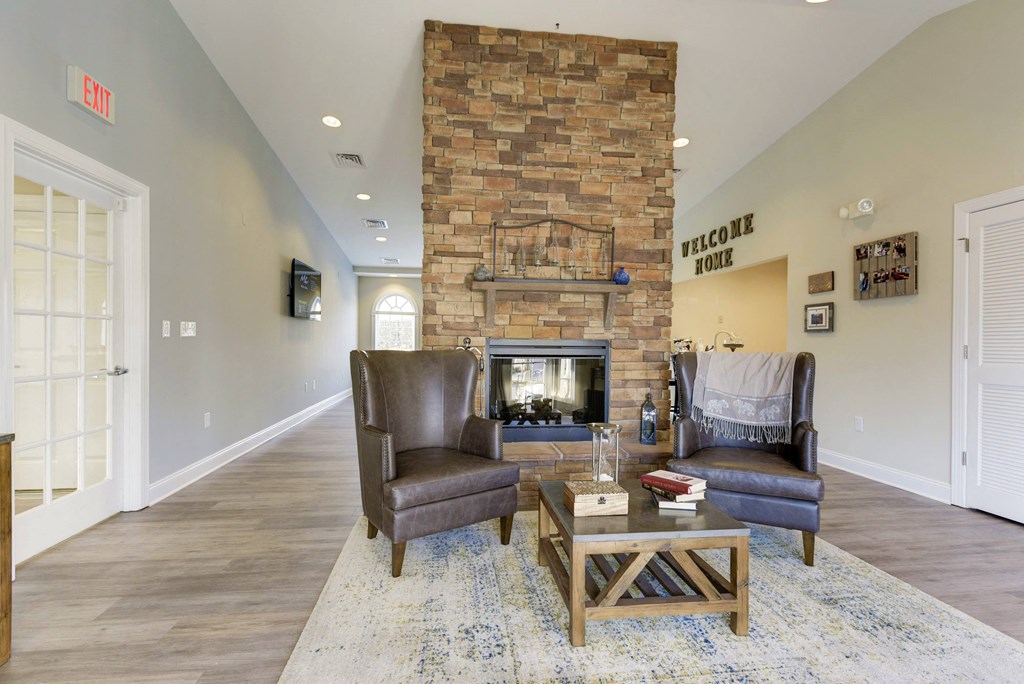 a living room with a fireplace and two chairs
