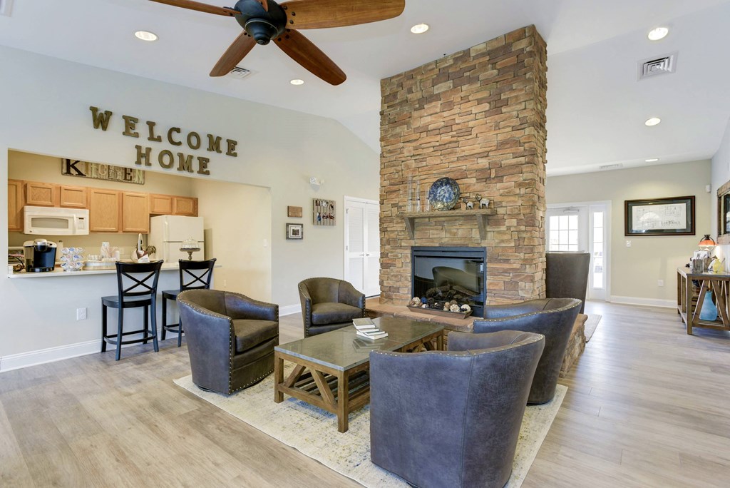 a living room with a stone fireplace and a table and chairs