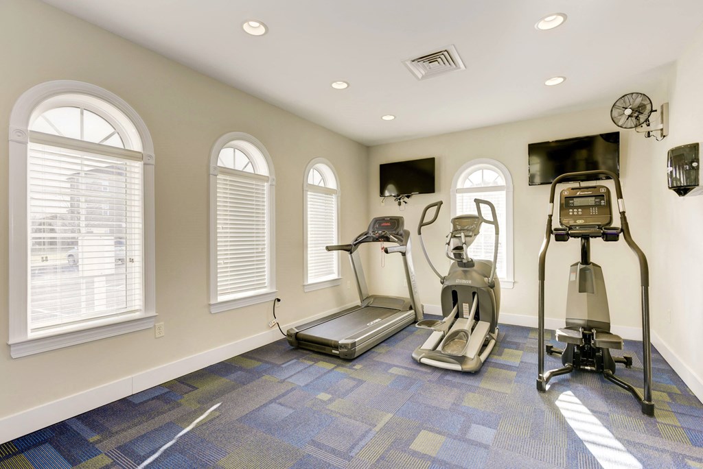 a home gym with exercise equipment and windows