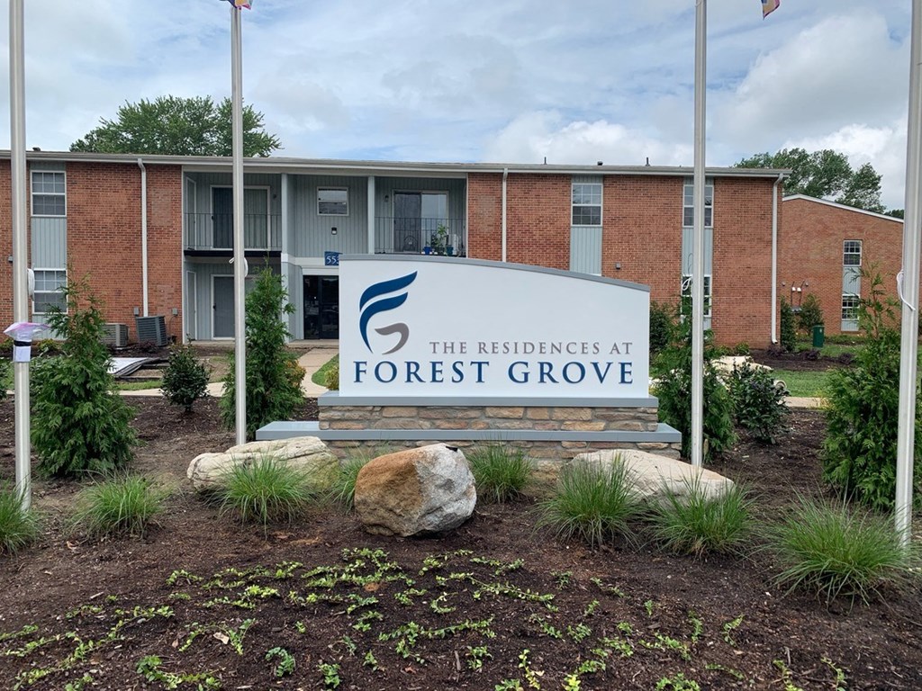 a sign with the words forest grove in front of a brick building