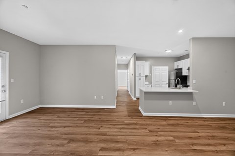 A kitchen with a refrigerator, sink, and cabinets.
