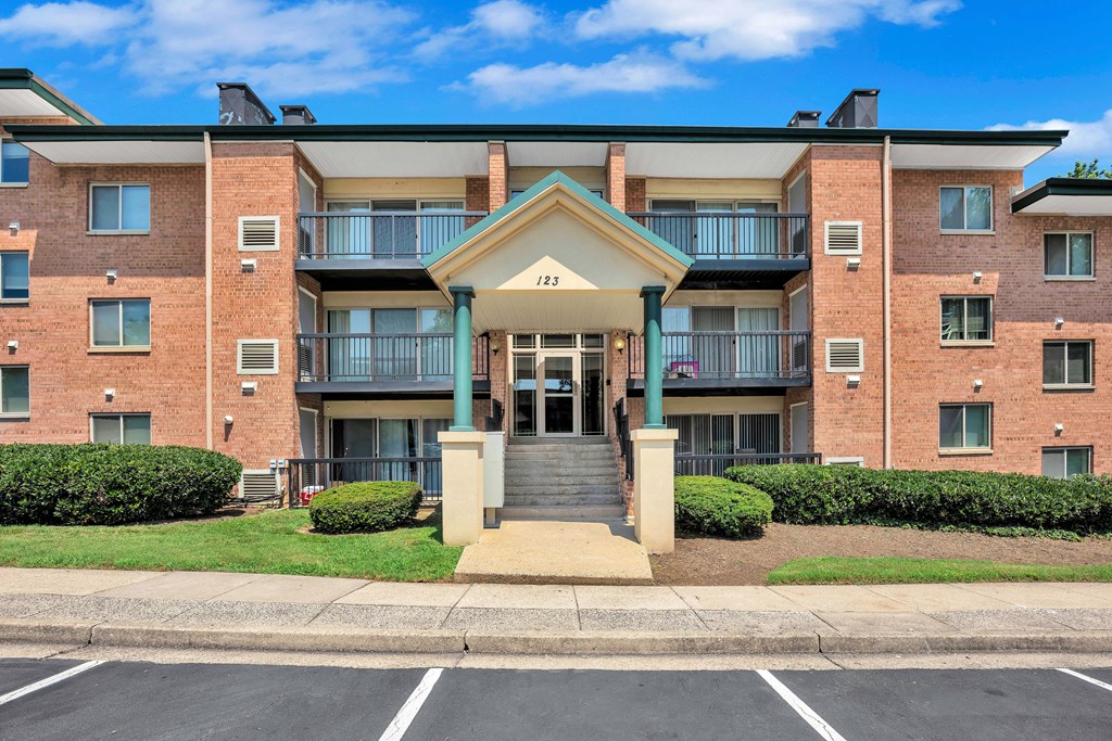 A large brick building with a balcony and a small entrance.