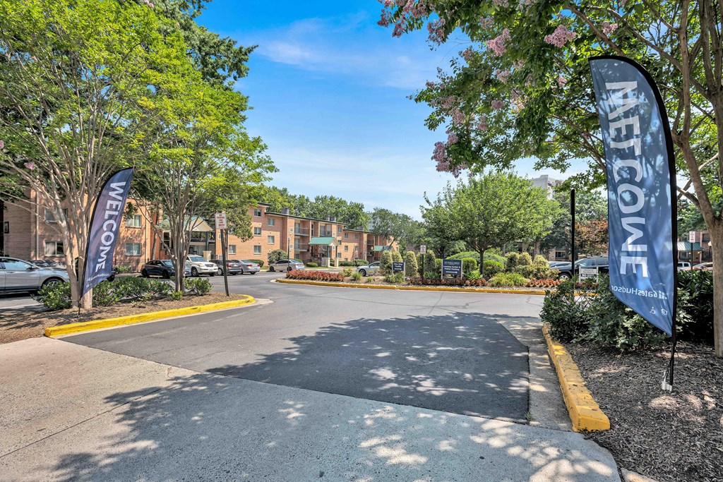 A street view of a residential area with a sign that reads