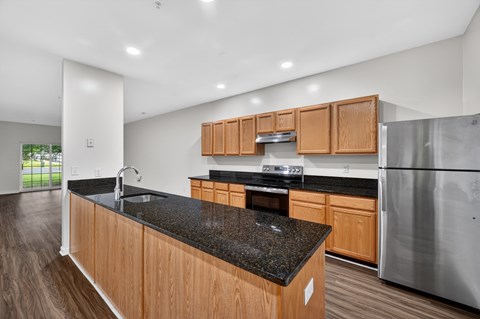 A kitchen with wooden cabinets and a black countertop.