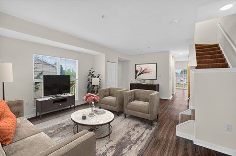 A living room with a grey sofa, a white coffee table, and a brown armchair.