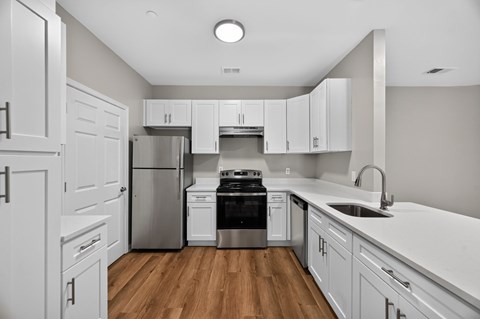 A kitchen with white cabinets and a stainless steel refrigerator.