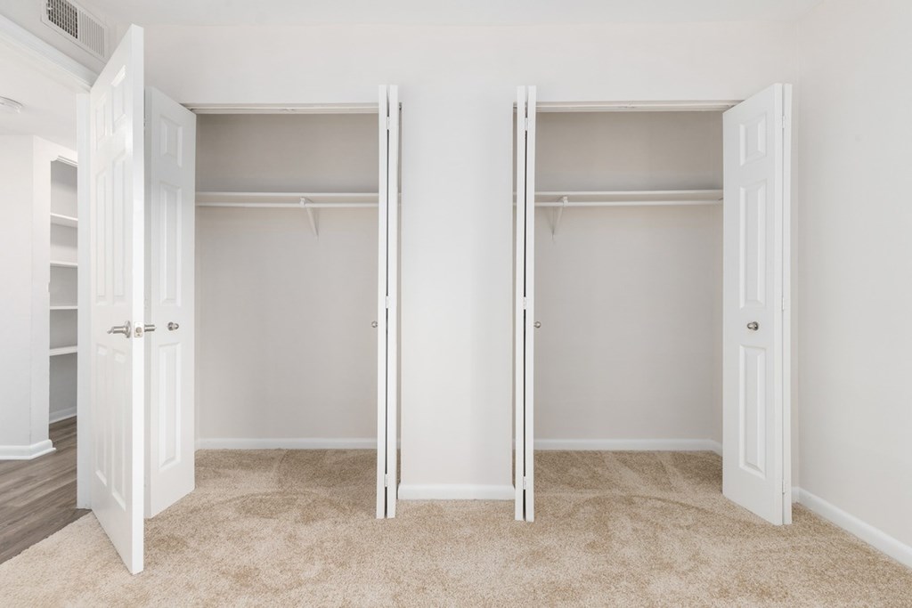 Two white closet doors with shelves inside.