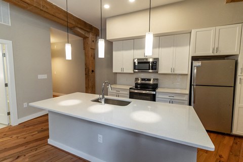a kitchen with a white counter top and a stainless steel refrigerator