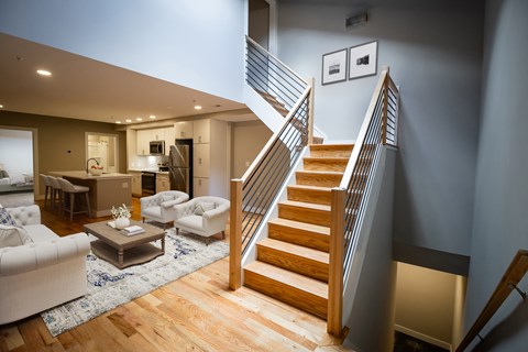 A staircase with a wooden handrail leads to a second floor.