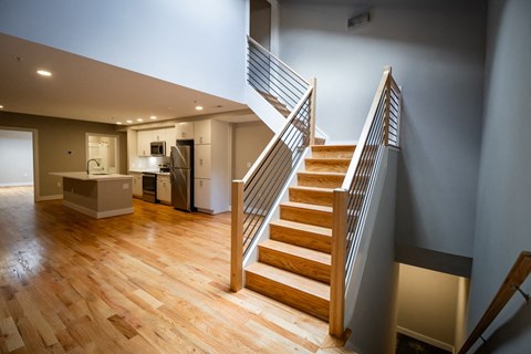 a view of a staircase in a home with wood floors and a kitchen