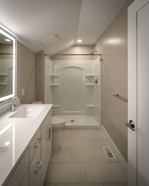 a bathroom with a shower and a sink and a toilet