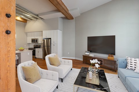 A living room with a white couch and a black coffee table.